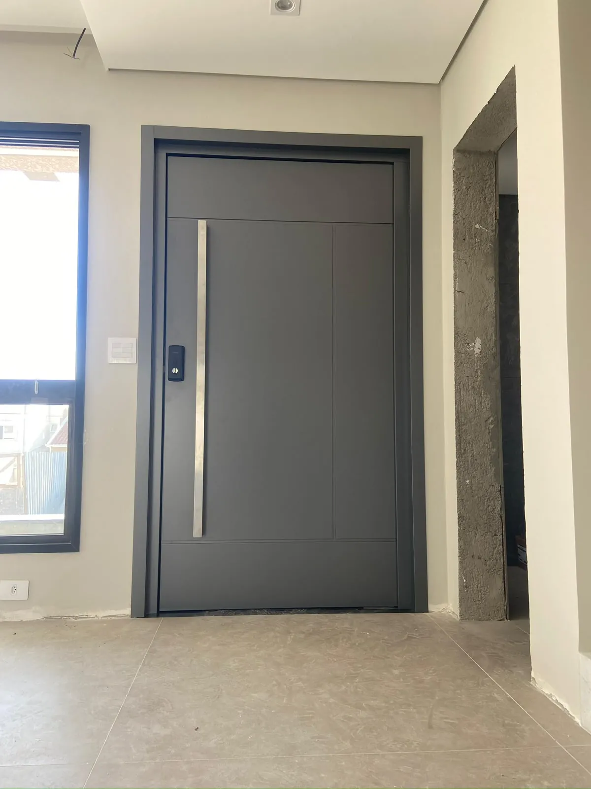 Porta em ACM cinza grafite com fechadura eletrônica e puxador de inox